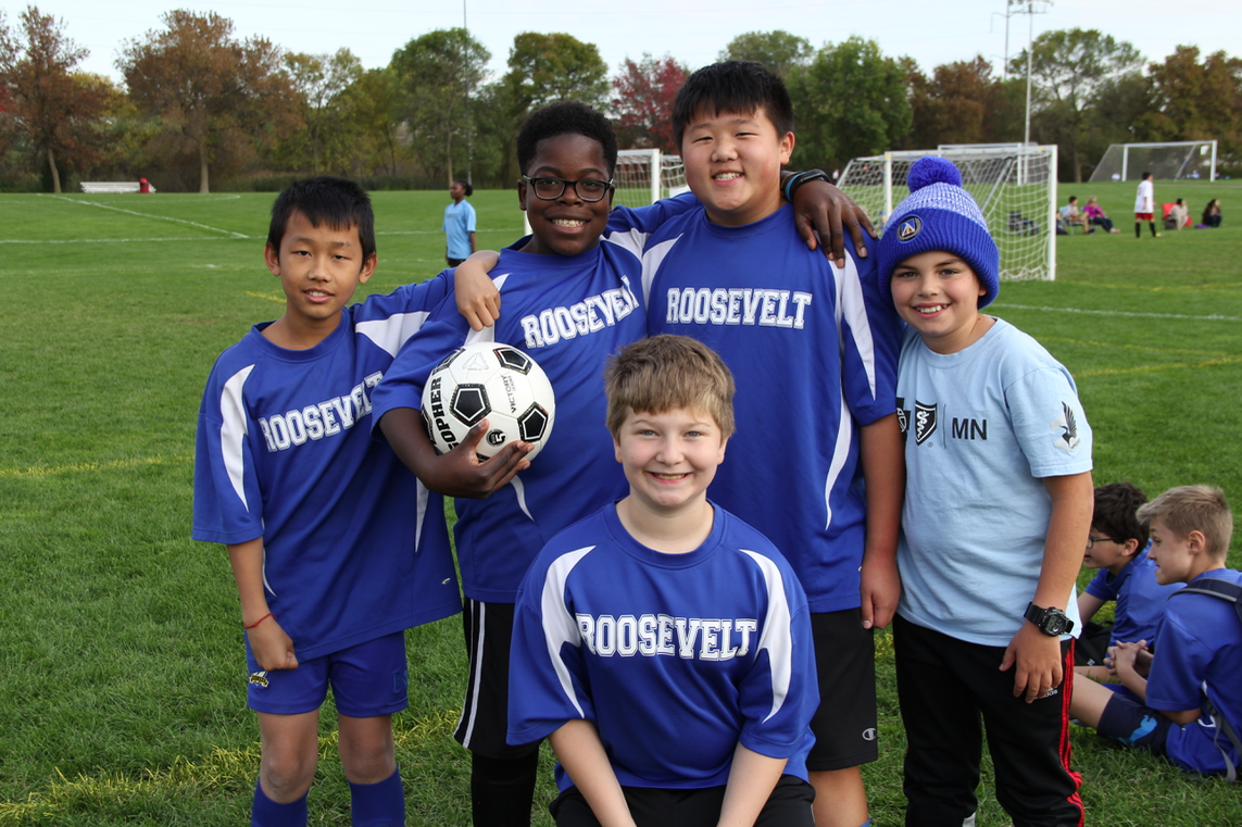 Soccer students smiling on the sidelines 